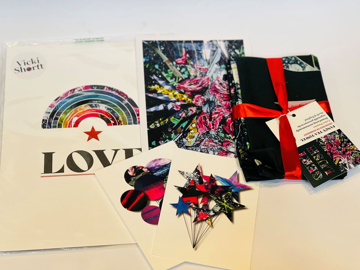 Vicki Shortt art prints, art cards and a tea towel arranged on a white surface
