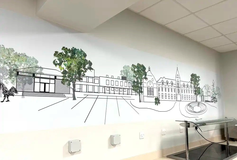 Corporate Landscape Art of King's College, Taunton - A large black and white architectural line drawing of a campus or institutional building complex with trees, mounted on a white wall in an indoor room. Part of a stainless steel counter or table is visible in the lower right corner.