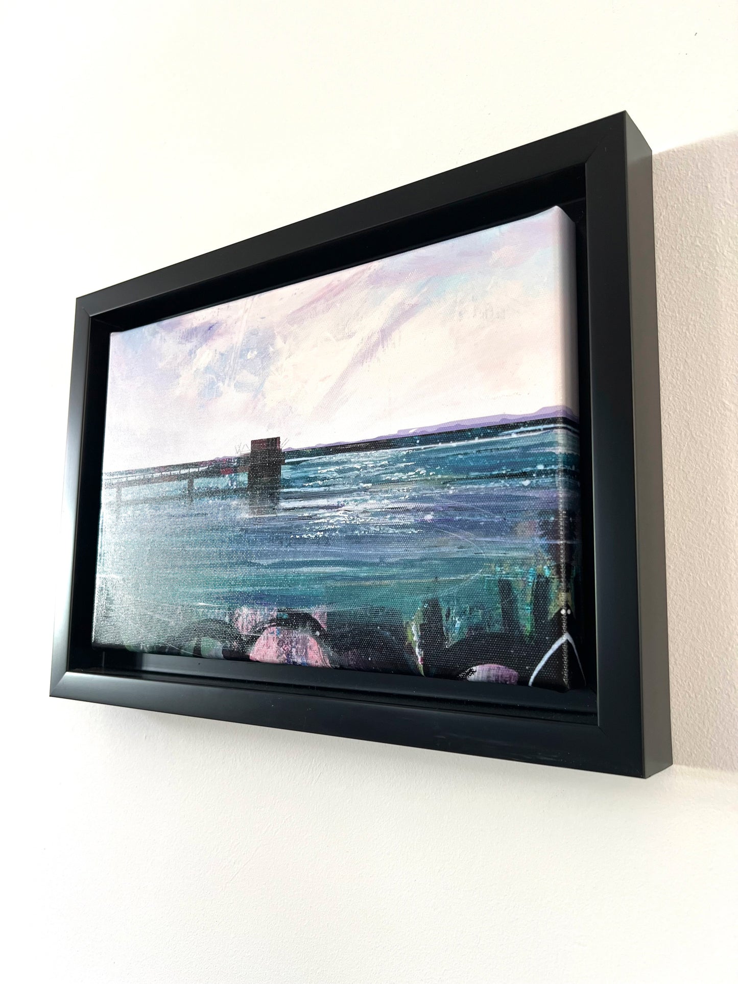 Covenham Reservoir original artwork by Vicki Shortt, the bank and open water of Covenham Reservoir, Lincolnshire, the framed canvas seen at an angle