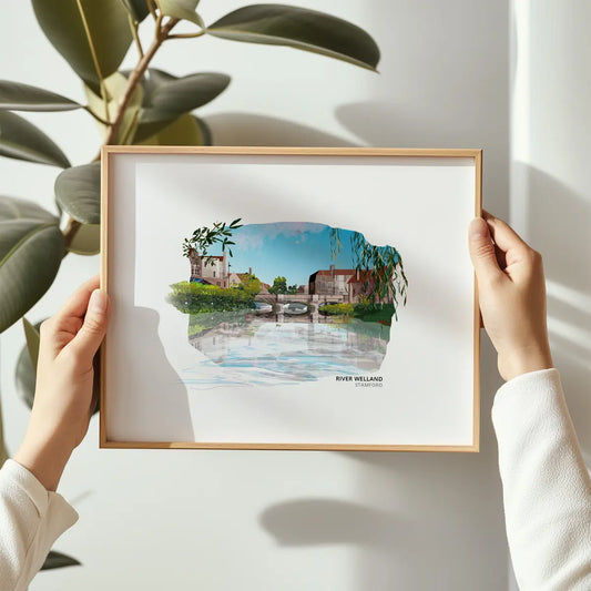 River Welland art print by Vicki Shortt, the river flowing through Stamford against the town's limestone buildings, Lincolnshire, framed in a room setting